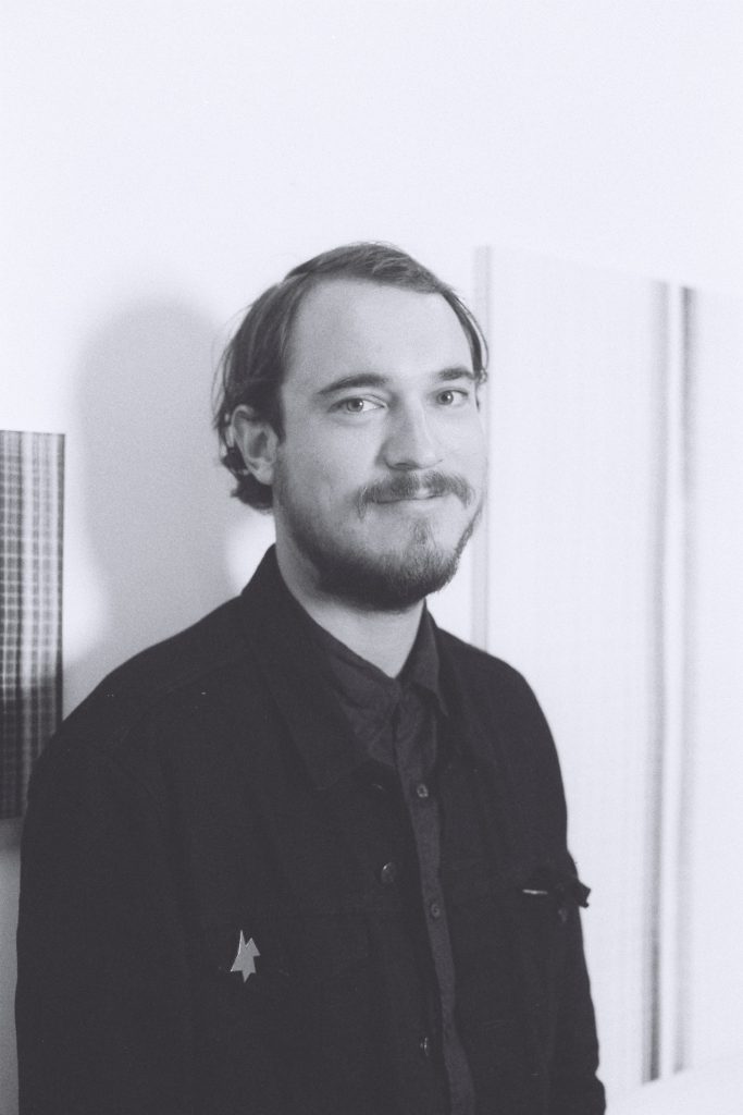 Laszlo Thorsen-Nagel portrayed by Wolfgang Jarnach in front of paintings